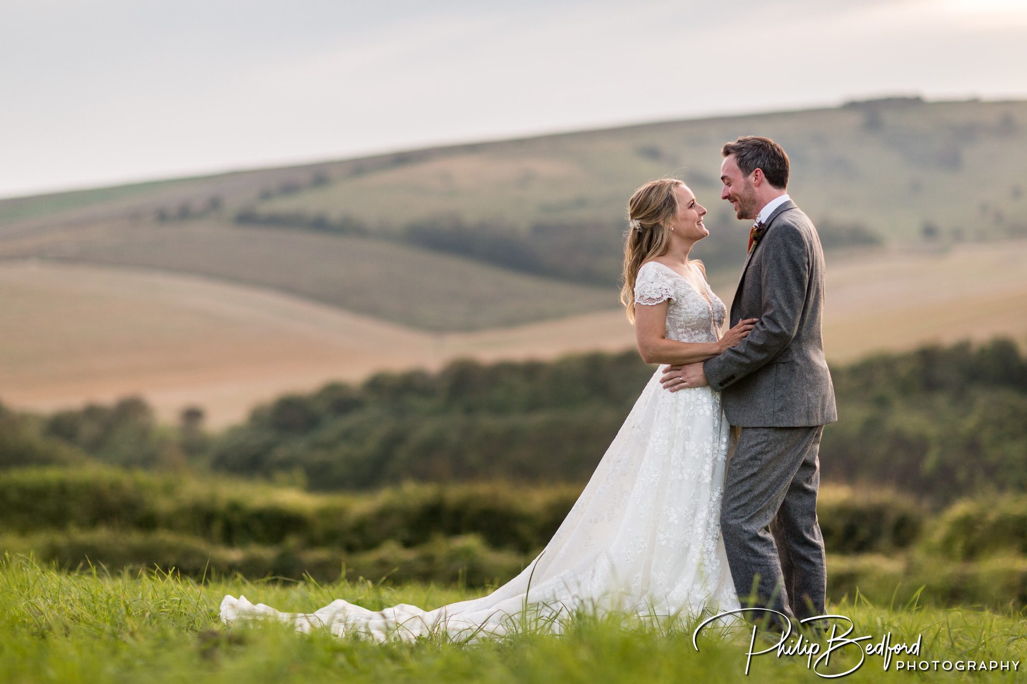 The bride and groom with the South Downs in the background at a Pangdean Barn Wedding
